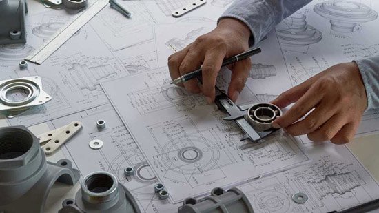 Engineer measuring a part against technical drawings